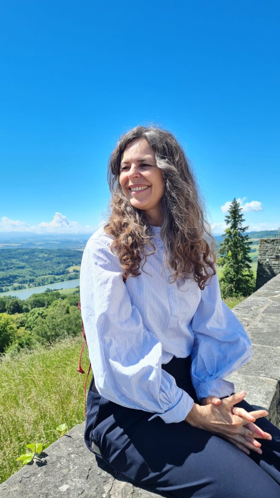 f7da68b5-26f6-4d36-85be-ec257110f20c Astrid sitzt auf einer Steinmauer